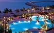 Hotel je zgrajen v obliki vala in je sestrski hotel Burj al Arab-a. Leži neposredno na peščeni plaži Jumeirah s čudovitim pogledom na zaliv in okolico.